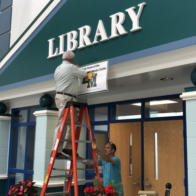 man hanging a banner